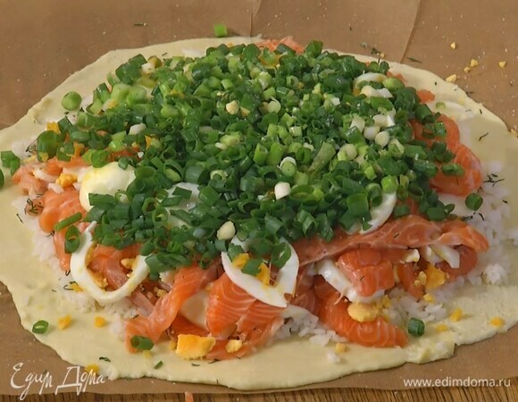 На один пласт теста, отступив немного от бортика, равномерно выложить рис, слегка посолить его и посыпать укропом, сверху разложить половину рыбы и яиц, посолить, выложить еще слой рыбы и слой яиц, присыпать все зеленым луком, посолить и накрыть вторым пластом теста и защипнуть края.