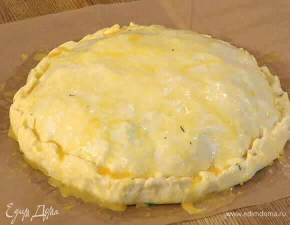 Желток размешать с молоком и щепоткой соли, смазать кулебяку и перенести ее вместе с бумагой для выпечки на противень.