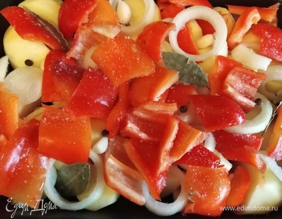 Овощи вымыть и очистить. Клубни картофеля разрезать пополам. Болгарский перец нарезать на куски. Лук — кольцами. Зубчики чеснока оставить целыми. Выложить все ингредиенты в форму для запекания. Посолить. Добавить лавровый лист и душистый перец. Форму накрыть фольгой. Поставить в разогретую духовку.