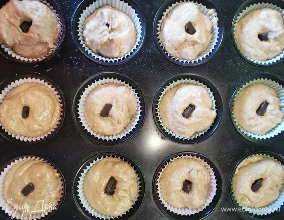 Влейте тесто и в середину каждой заготовки вдавите кусочек шоколада.