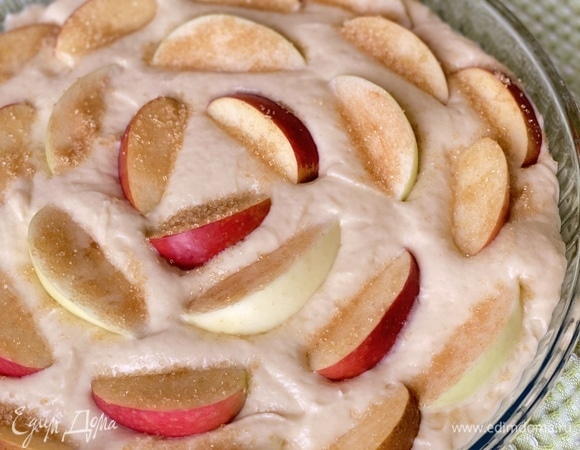 Вылить тесто в форму для запекания, смазанную сливочным маслом. Сверху выложить дольки яблок. Можно посыпать сахаром и корицей. Выпекать при 180°C около 40 минут.