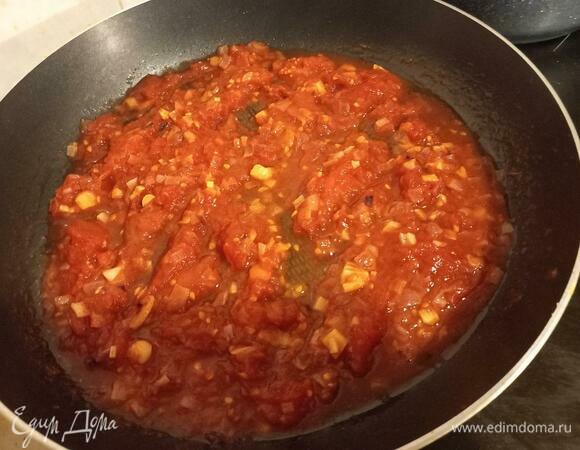 Добавляем размятые томаты к зажарке, убавляем огонь до среднего, закрываем крышкой на 5 минут. Соус немного прокипит и загустеет.
