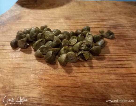 Режем каперсы пополам.