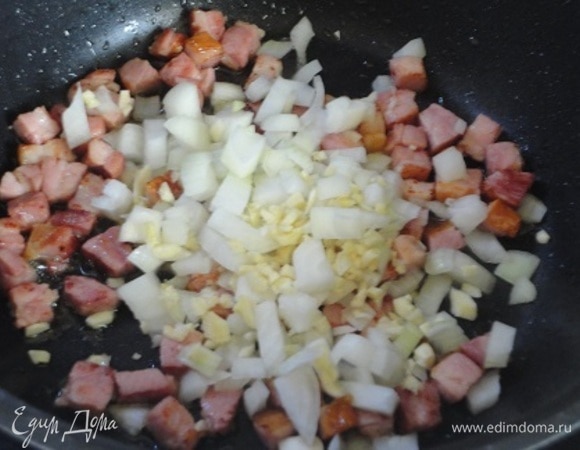 Бекон нарезать кубиками со стороной в 1 см и обжарить на оливковом масле. Добавить нарезанный мелкими кубиками лук и рубленый чеснок. Пожарить только до прозрачности.