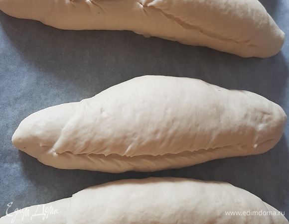 У каждого хлебушка сбоку сделать надрез. Потом накрыть вторым противнем сверху. Выпекать сначала 15 минут при 250°C. После этого снять противень и выпекать еще 20 минут при 200°C.