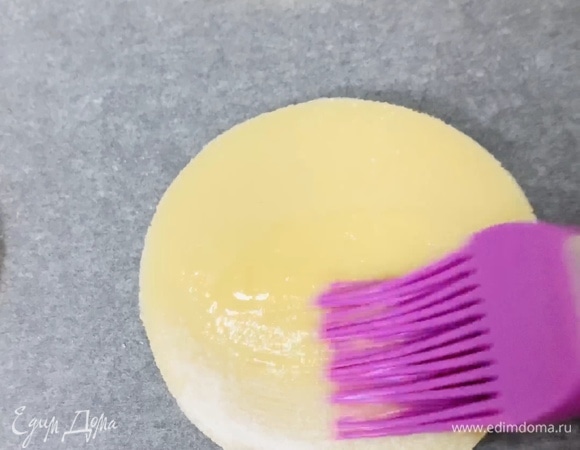 Перекладываем на противень, застеленный пергаментом. Смазываем поверхность коржей оставшимся взбитым яйцом.