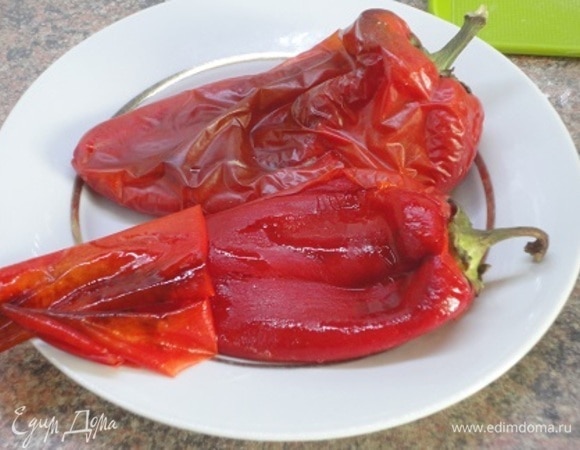 Одновременно с курицей запекать два перца минут 25, перевернув пару раз. Запеченный перец оставить в кастрюле под крышкой. Как только он остынет, снимете кожицу, удалите семена и нарежьте на кусочки.