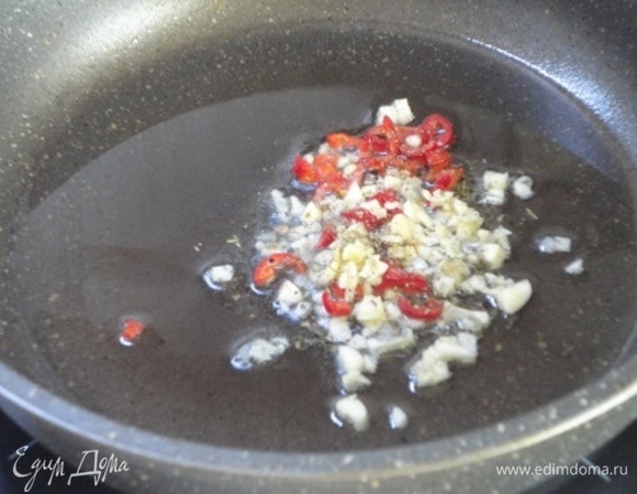 Для соуса чеснок и перец чили измельчить. Помидоры очистить от кожицы и натереть на терке. В сковороде разогреть оливковое масло и обжарить чеснок с перчиком, приправив майораном.