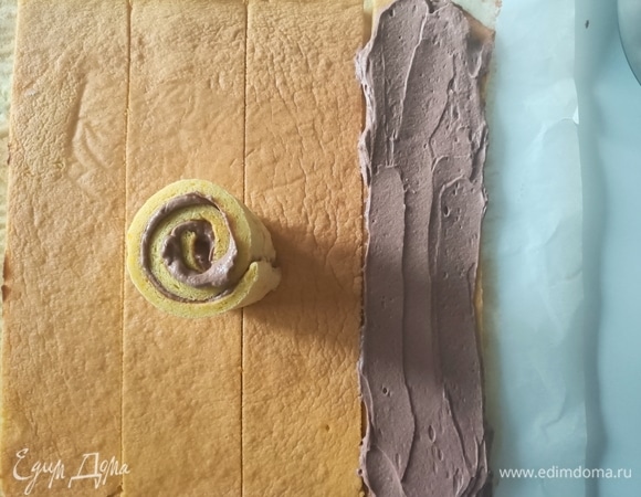 На полоску бисквита выложить немного крема, скрутить и поставить на блюдо.