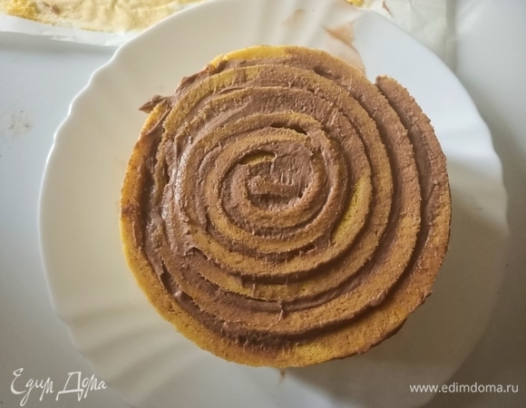 Далее выложить крем на следующую полоску бисквита, приставить ее к концу первой и продолжить заворачивать рулет до тех пор, пока не закончится весь бисквит.