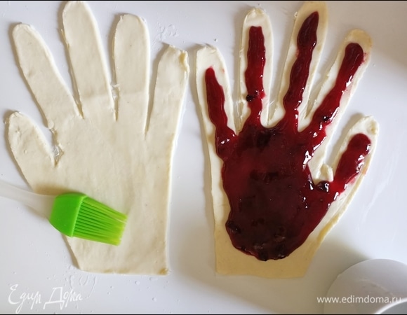 На одну часть «руки» выложить немного варенья, не доходя до краев. Края смазать водой или молоком.