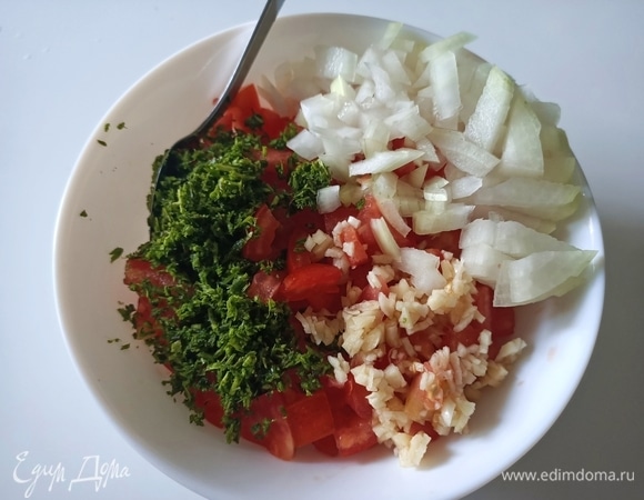 Филе рыбы необходимо промыть под проточной водой, обсушить бумажным полотенцем, посолить, поперчить со всех сторон, сбрызнуть лимонным соком и отложить в сторону. Пока рыба маринуется, делаем овощную прослойку. Помидоры разрезаем пополам, удаляем жидкость с косточками и нарезаем небольшими кубиками. Добавляем мелко нарезанный чеснок, укроп и лук, солим, перчим, поливаем оливковым маслом и перемешиваем.