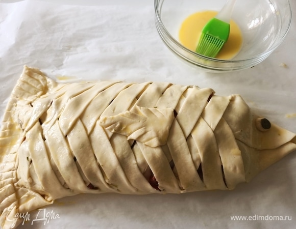 Низ теста переворачиваем, закрепляем его, немного надавливая пальцами, аккуратно с помощью ножа делаем надрезы, не доходя до конца. Хвост готов. Теперь из обрезков теста делаем плавник и глаз рыбы.
