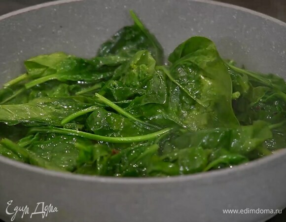 Разогреть в сковороде оливковое масло и слегка прогреть чеснок, всыпать чили, добавить сливочное масло, все перемешать, затем выложить в сковороду шпинат и дать ему поплыть.