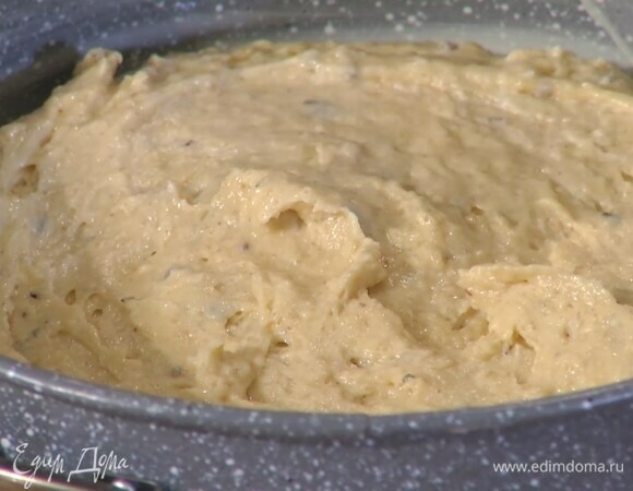 Дно разъемной формы выстелить бумагой для выпечки, смазать все внутри сливочным маслом, выложить тесто и разровнять лопаткой.