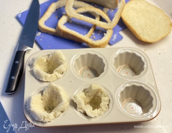 Из хлеба вырезать кружочки. Утрамбовать их в форму для маффинов.