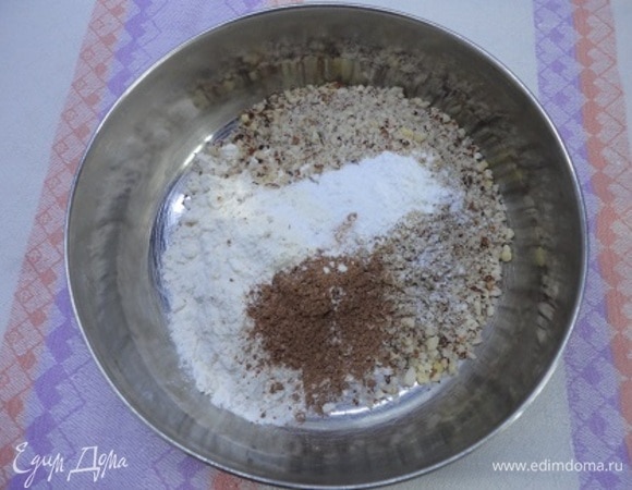 Орехи измельчаем. Просеиваем муку и смешиваем ее с разрыхлителем, корицей, солью и орехами. Разогреваем духовку до 180°C.