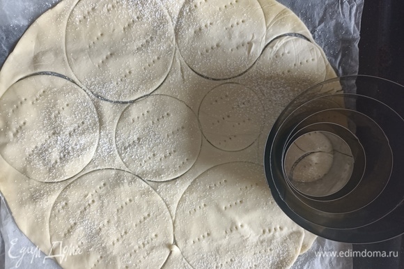 Я делаю круглые пирожные, но если вам нравится, то можно сделать квадратные или прямоугольные, все зависит от фантазии и купленного вами теста. Разогреваем духовку до 180°C. Разворачиваем готовое слоеное тесто, немного раскатываем и вырезаем круглые заготовки с помощью формочек или же стакана. Тесто прокалываем вилкой в нескольких местах, посыпаем сахарной пудрой и выпекаем в уже разогретой духовке в течение 10 минут до золотистого цвета. Готовые слоеные диски достаем из духовки и полностью остужаем.