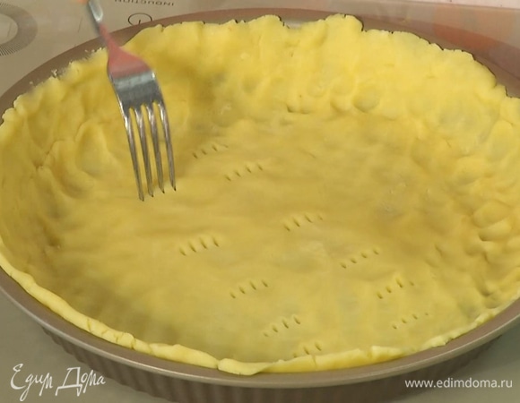 Охлажденное тесто выложить в форму и равномерно распределить, сделать несколько проколов вилкой, затем накрыть бумагой для выпечки, засыпать любыми бобовыми и выпекать в разогретой духовке 20 минут.