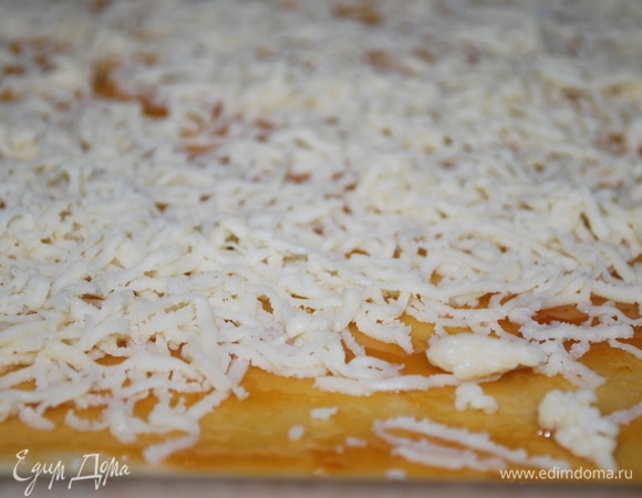 Достать тесто из морозильной камеры и натереть его на мелкой терке на слой мармелада. Выпекать при 170°C примерно 25–30 минут.