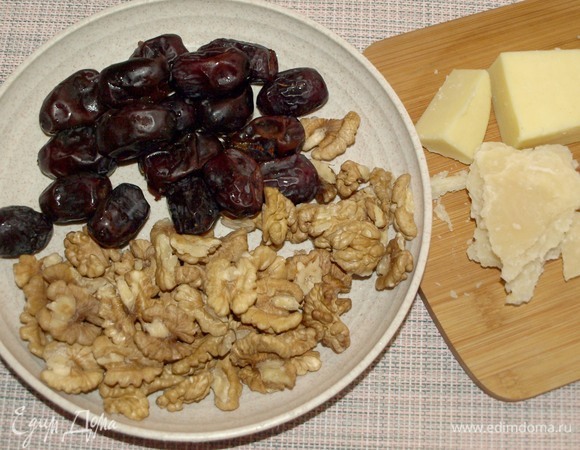 Подготовить продукты. Из фиников извлечь косточки. Сыр натереть на мелкой терке. Убедитесь, что орехи полностью очищены от перегородок. Сахарную пудру соединить с корицей.