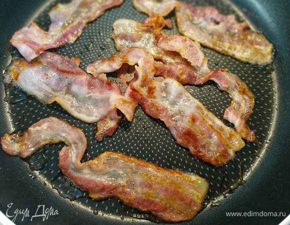 Полоски бекона обжарить на сухой сковороде с обеих сторон.