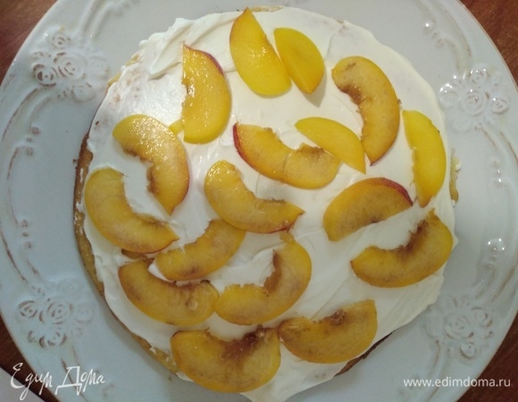 Сборка торта. Персики нарезать тонкими ломтиками. Корж смазать кремом, разложить персики. Снова — корж, крем, персики. Можно чередовать через раз. Фрукты или ягоды берите по вкусу. Верх торта и бока смазать кремом. Если хотите украсить торт глазурью, то верх оставьте без крема. Убрать в холодильник на ночь или на 5–6 часов.