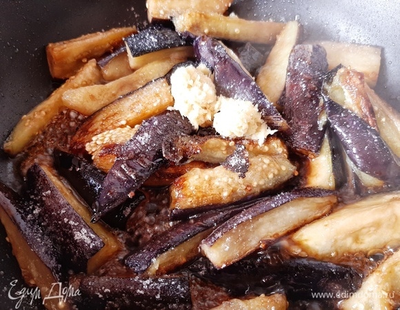 Имбирь натираем на мелкой терке и отправляем к баклажанам, добавляем соевый соус и сахар. Хорошо перемешиваем и наливаем немного воды, чтобы баклажаны были наполовину в соусе. Закрываем крышкой и готовим на медленном огне 10–15 минут, до мягкости. Слегка подсушиваем кунжут на сухой сковороде. Готовые баклажаны посыпаем кунжутом. Приятного аппетита!