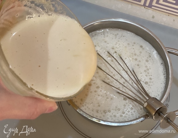 Часть горячего молока медленно влить в яичную смесь. Перемешивать до однородности. Затем влить в кастрюлю с оставшимся молоком.