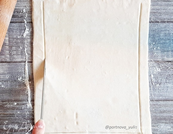 Тесто немного раскатываем и делаем неглубокие надрезы вдоль всего края, отступив около 1,5 см.