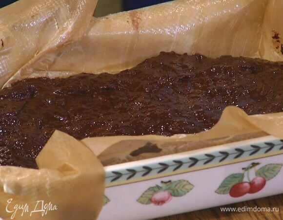 Керамическую форму выстелить бумагой для выпечки, смазанной оставшимся сливочным маслом, выложить шоколадную массу и разровнять ее.