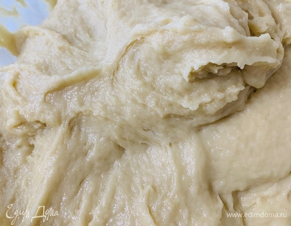 С помощью лопатки все перемешиваем. Затем замешиваем руками до момента, пока тесто не станет немного отставать от рук и стенок миски, но по-прежнему будет достаточно липким. Старайтесь муки не добавлять, так как чем ее больше, тем плотнее будут булочки.