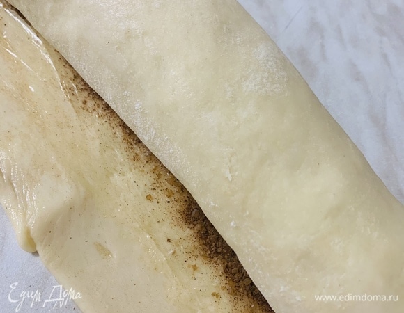 Скручиваем рулет. Чистый край промакиваем слегка влажными руками и склеиваем.