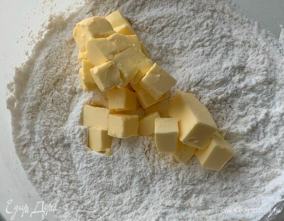 Мягкое сливочное масло (достаньте его за 30 минут из холодильника) нарежьте небольшим кубиком и добавьте к муке, перетрите тесто в мелкую крошку.