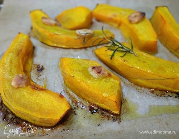 Тыкву нарезать на крупные куски, полить растительным маслом, добавить зубчик чеснока, веточку розмарина и запечь в духовке до золотистого цвета.