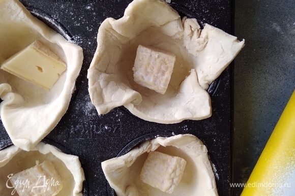 Сыр бри нарезать кусочками. Положить по кусочку в каждую корзинку. По желанию можно добавить нарезанный чеснок.