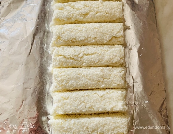 После холодильника нарезаем брусок на равные части и пальцами слегка закругляем края каждого батончика.