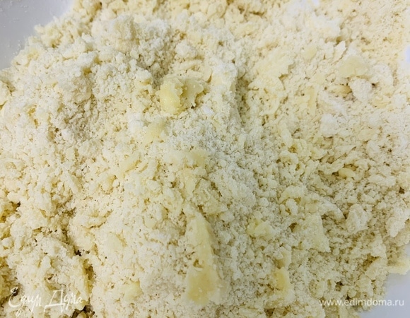 Разогреваем духовку до 170°C. К просеянной муке добавляем соль и сахарную пудру. Туда же отправляем мелко нарезанное масло и растираем руками с мукой, пока смесь не превратится в крошку.