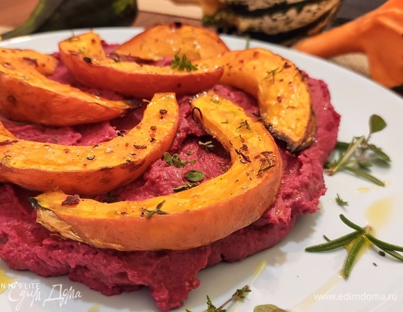 Выложите теплую тыкву на хумус, сбрызните оливковым маслом и посыпьте зеленью. Листики тимьяна, веточки петрушки придадут блюду приятную свежесть.