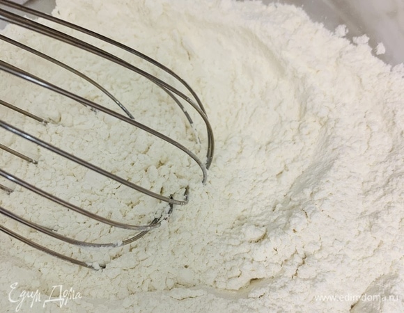 Разогреваем духовку до 200°C. В просеянную муку добавляем сахар, соль и перемешиваем.