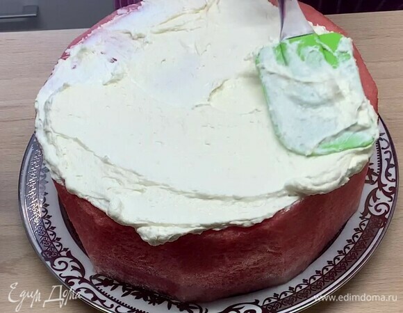 Смешайте сметану и сливочный сыр, смажьте арбуз со всех сторон, стараясь полностью покрыть его.