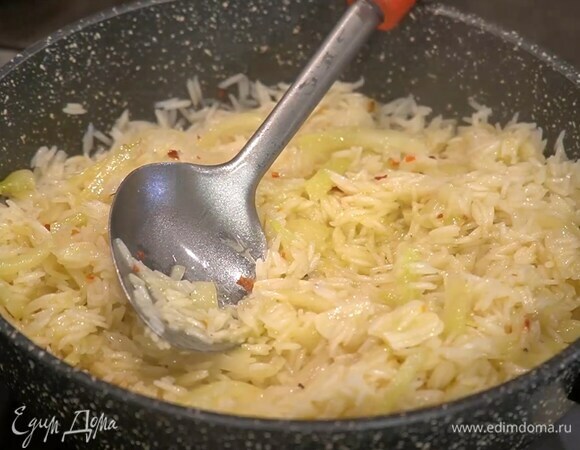 Всыпать к овощам рис и, помешивая, слегка обжарить, влить вермут и дать алкоголю выпариться, затем добавить бульон, перемешать, накрыть крышкой и готовить на маленьком огне около 15 минут, по необходимости доливая бульон.