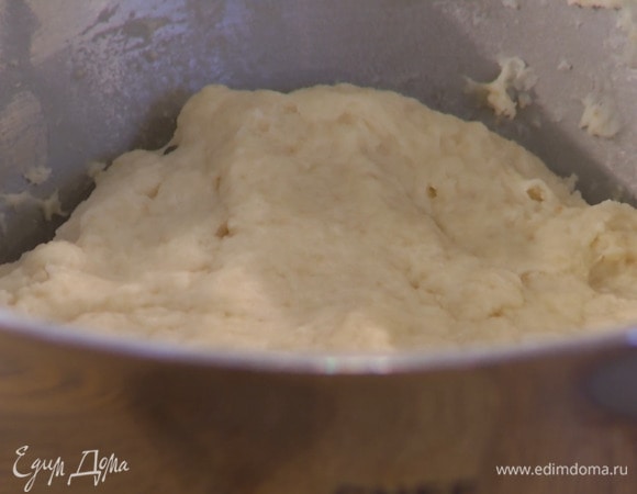 Перемешать 500 г муки с дрожжами и солью, затем, не выключая комбайна, небольшими порциями всыпать муку в молочную смесь и продолжать вымешивать, пока не получится однородное тесто.