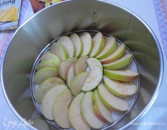 Подготовить форму диаметром 20–21 см: смазать дно и бока маслом. Яблоки (у меня указан чистый вес, без серединки) нарезать на дольки и уложить на дно. Духовку разогреть до 180°C.