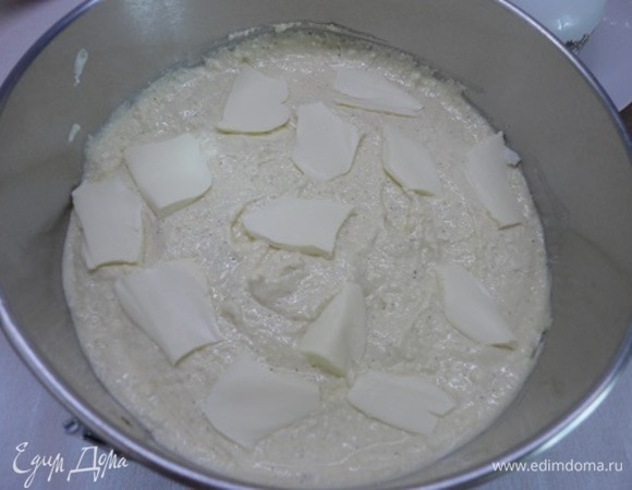 Выложить творожную массу поверх яблок, разровнять. Сверху выложить кусочки сливочного масла и посыпать коричневым сахаром.