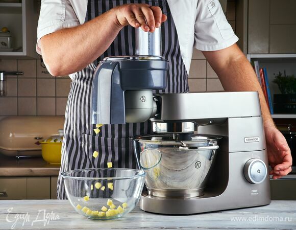 Овощи для супа очистите. Установите на кухонную машину насадку-овощерезку и нарежьте кубиками картофель и очищенный помидор.