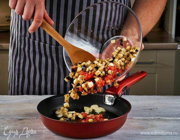 Налейте в сковороду оливковое масло и обжарьте в нем чеснок, добавьте баклажаны и помидоры. Тушите в течение 10 минут на среднем огне.