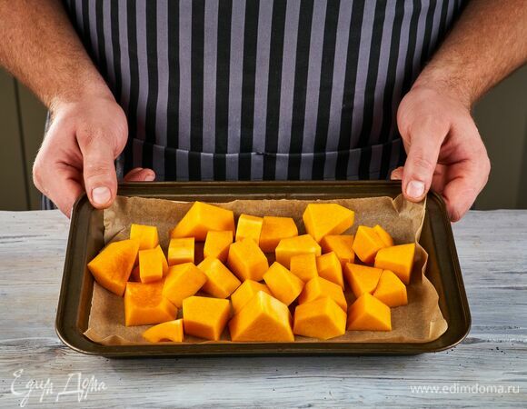 Очищенную тыкву нарежьте кусочками, положите на противень, застеленный пекарской бумагой, и запекайте при 200°С в течение 20–30 минут.