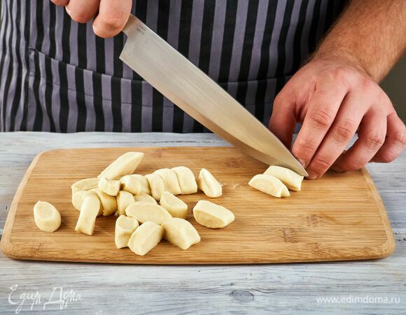 На рабочей поверхности скатайте из теста колбаски толщиной 2 см и нарежьте их на кусочки шириной 2 см.