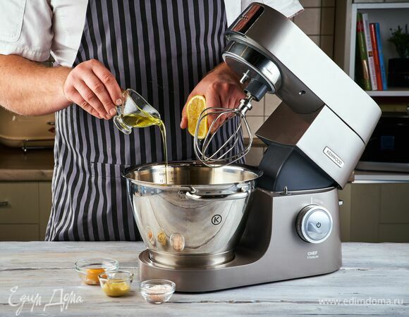 Приготовьте домашний майонез. Сделать это будет удобнее, используя кухонную машину. Установите насадку-венчик. В чаше соедините яичный желток, горчицу, соль. Слегка взбейте венчиком. Продолжая взбивать на низких оборотах, постепенно влейте тонкой струйкой часть оливкового масла.<br />
Когда майонез начнет становиться гуще, влейте 1 ст. л. лимонного сока. Добавьте тонкой струйкой оставшееся оливковое масло, продолжая взбивать венчиком. Майонез готов!